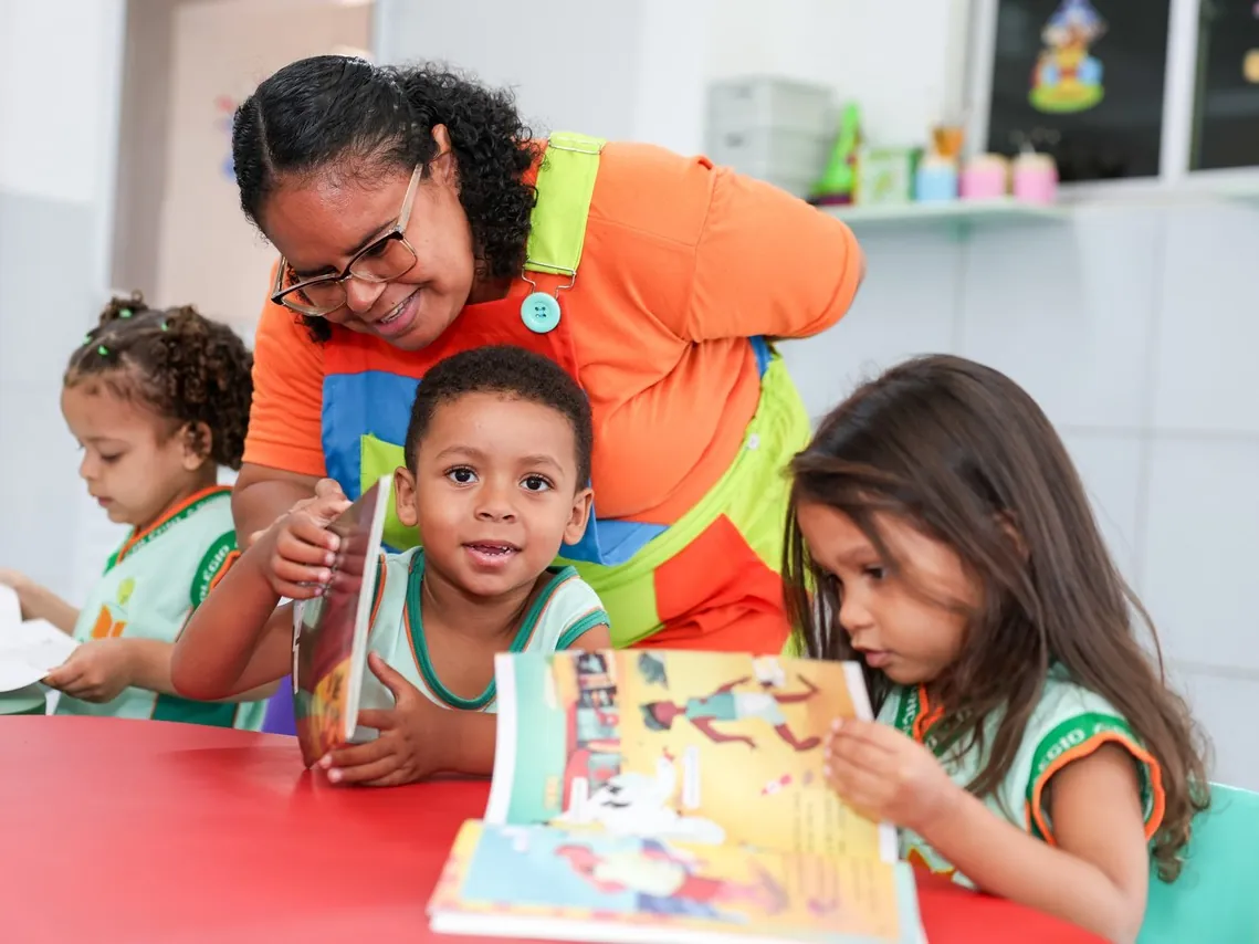 Professora lendo livro ilustrado com crianças da Educação Infantil no Assunção Kids
